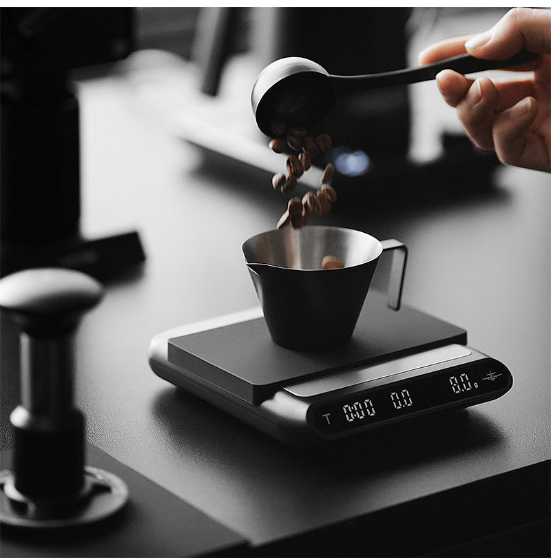 MHW-3BOMBER ES5486B black Formula coffee scale — weighing beans in a cup
