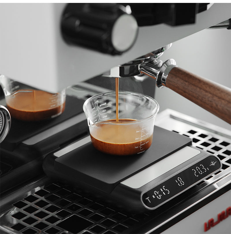 MHW-3BOMBER ES5486B black Formula coffee scale — espresso workflow with a clear cup