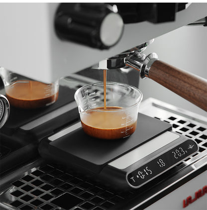 MHW-3BOMBER ES5486B black Formula coffee scale — espresso workflow with a clear cup