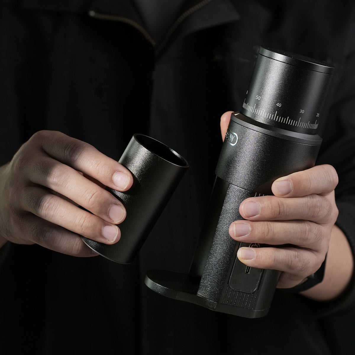 HiBREW G5mini grinder and removable grounds cup held in hand
