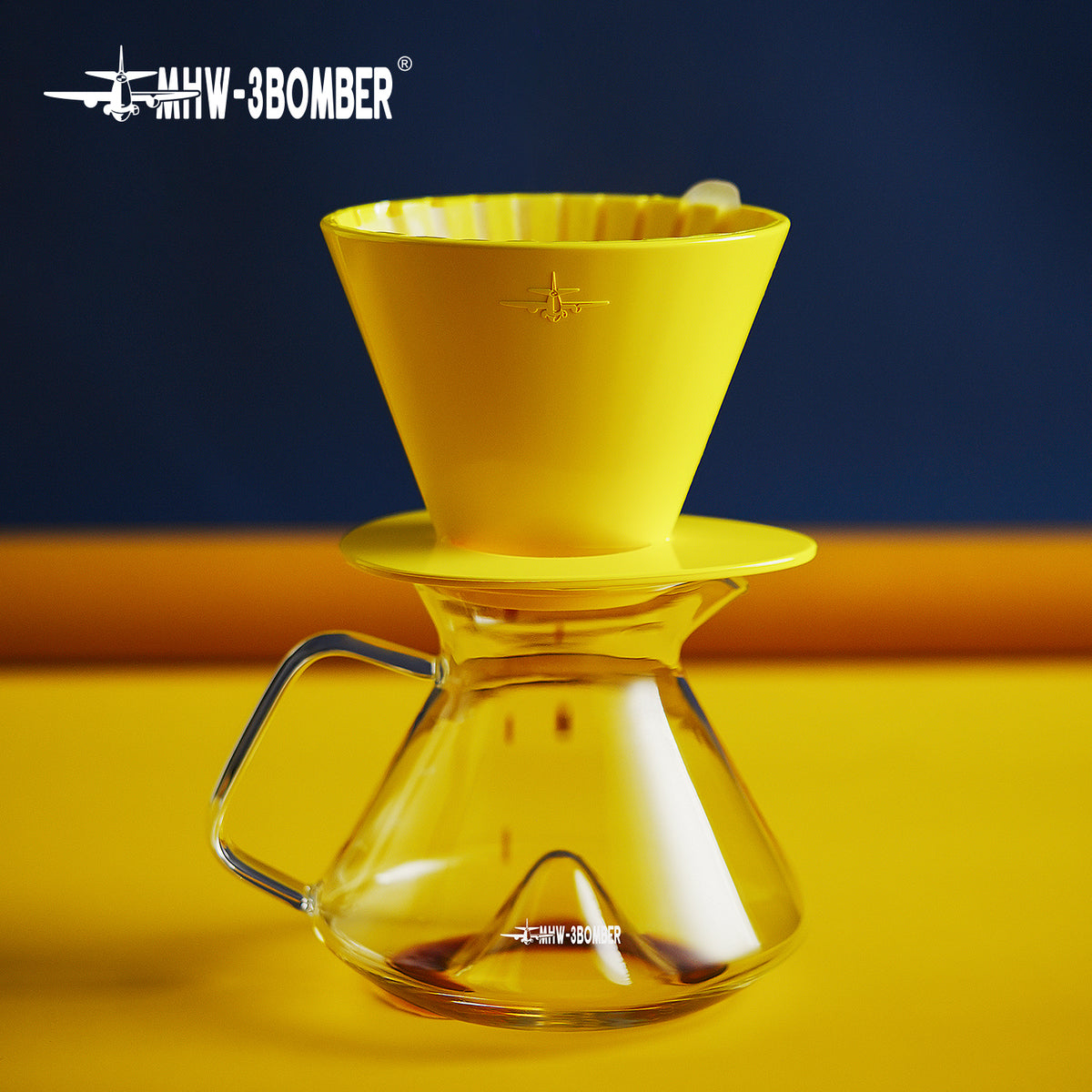 MHW-3BOMBER FC6606Y — yellow Oval dripper side profile resting on a server; other tools are scene props