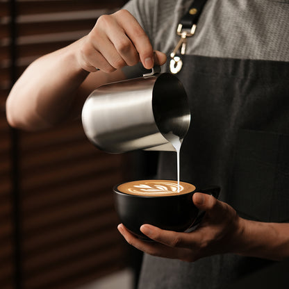 MHW-3BOMBER P5521 600 ml Silver Magician steaming pitcher pouring latte art into a separate cup; cup and drink are scene props, not included