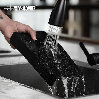 MHW-3BOMBER black flat A-style silicone mat being rinsed at a sink