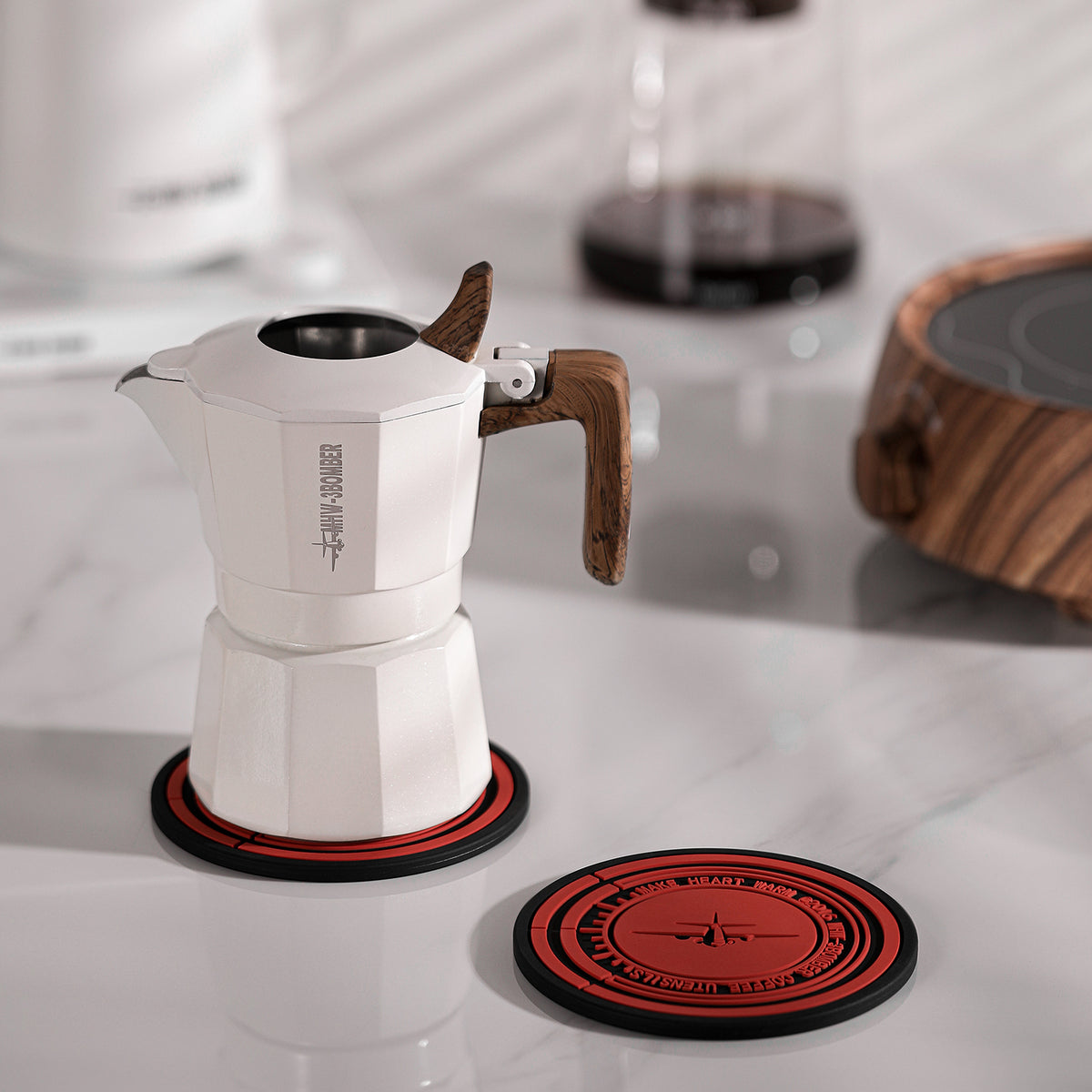 MHW-3BOMBER moka pot resting on a round mat on a light counter; pot separate
