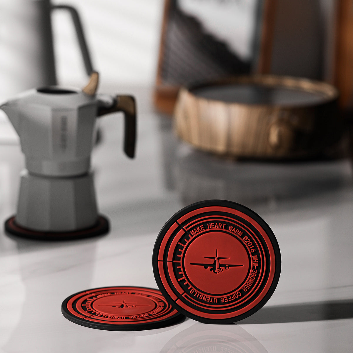 MHW-3BOMBER red and black mat standing upright beside a moka pot; pot separate