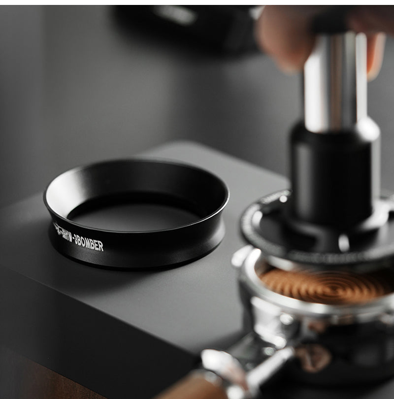 MHW-3BOMBER black magnetic dosing ring standing beside espresso tools