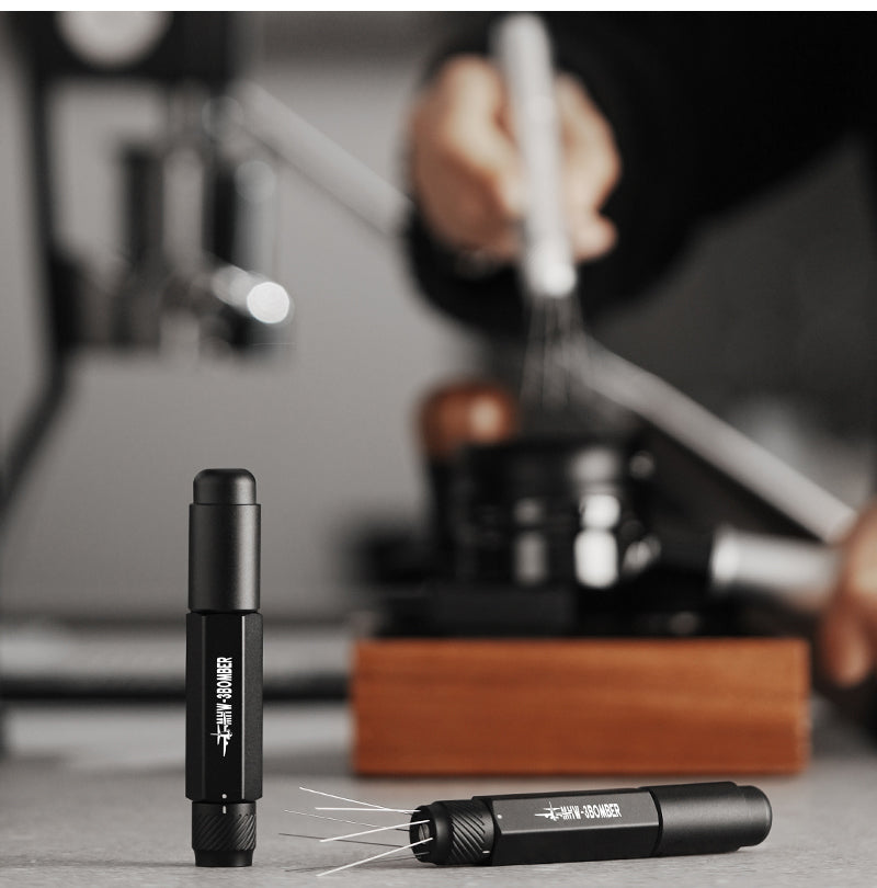 MHW-3BOMBER Lightning WDT Tool Pro T6188B Stellar Black tools with retracted and extended needles in a coffee-workspace scene; scene props and extra tools are not included