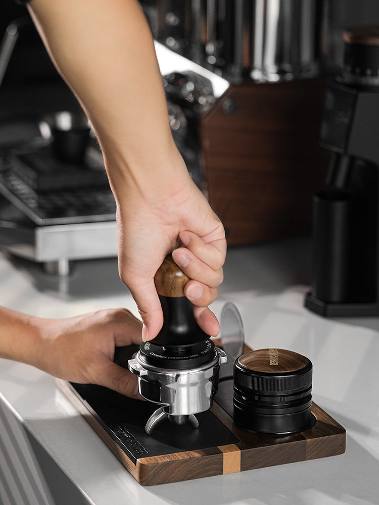 MHW-3BOMBER TS5151 wood tamping base supporting a portafilter during tamping; portafilter, tamper and distributor are props