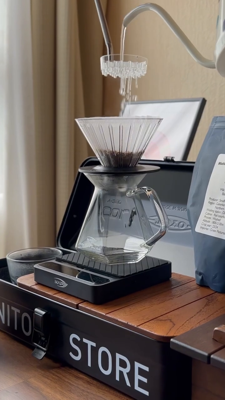 IKAPE V2 Pro black scale with silicone pad in pour-over use; separate brewing equipment is not included