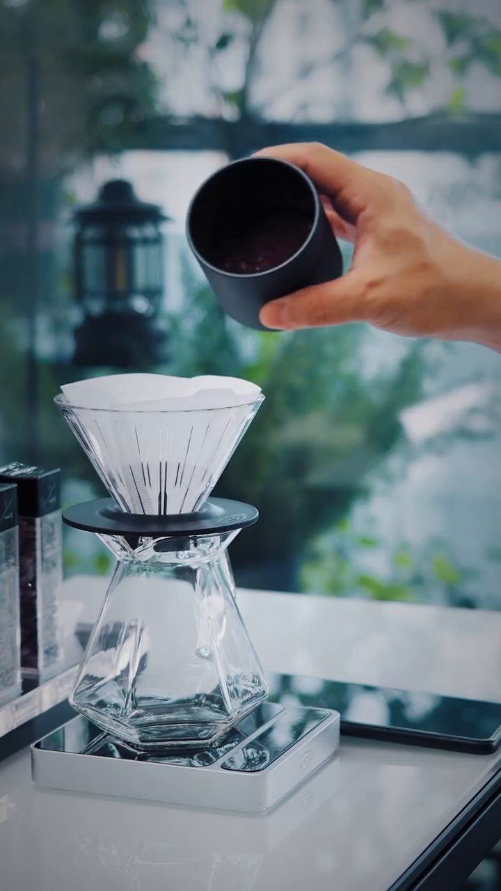 IKAPE V2 Pro silver scale supporting brewer during ground coffee dosing; separate brewing equipment is not included