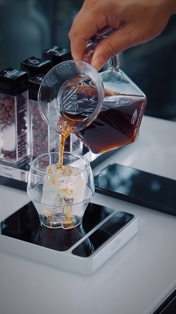 IKAPE V2 Pro silver scale weighing an iced serving during pouring; separate brewing equipment is not included