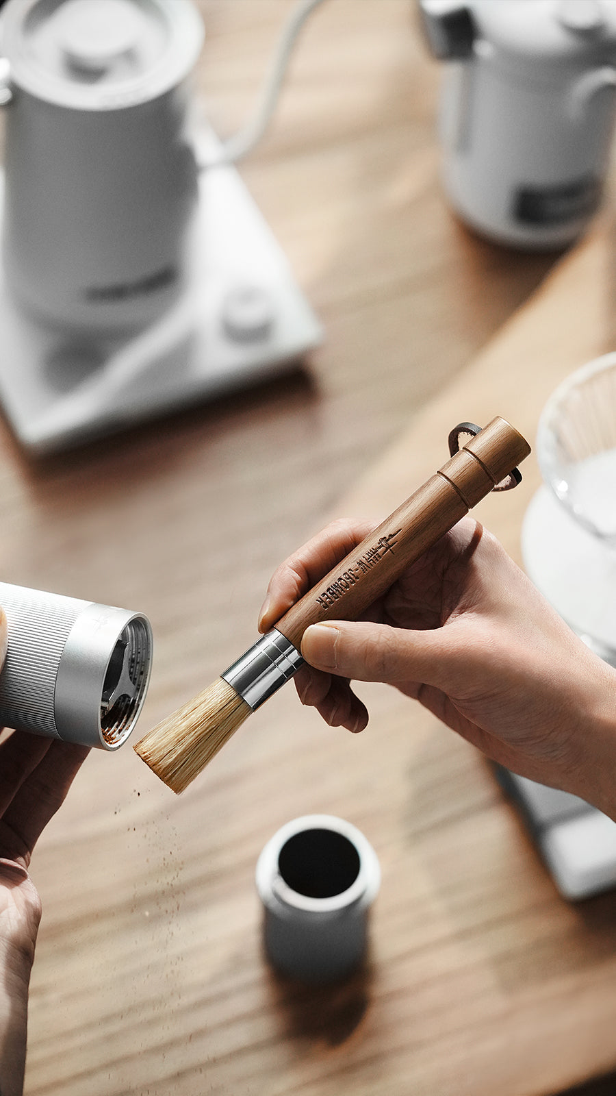 MHW-3BOMBER Wings brush held beside a coffee accessory